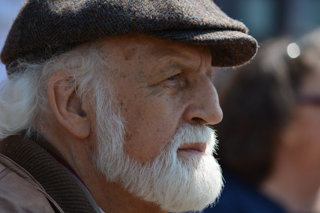 Retirement | Older man with a white beard and dark cap looking out into the distance